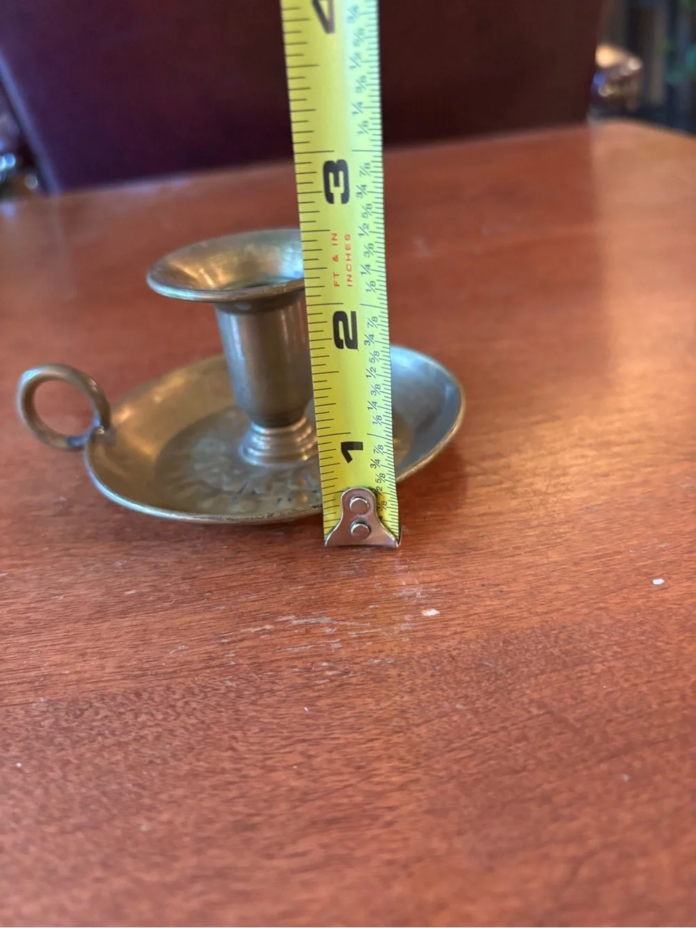 vintage brass chamberstick candle holder with a circular base and a ring handle